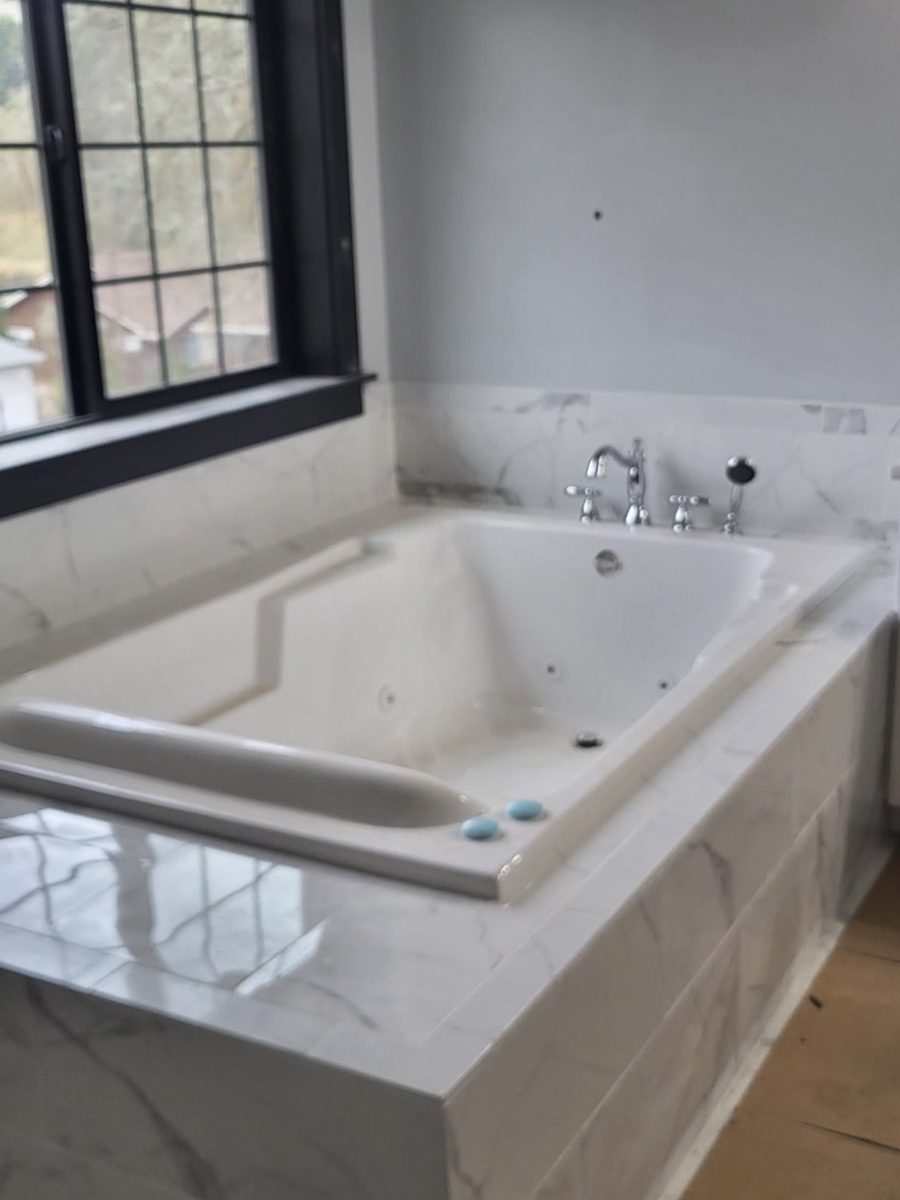 Jetted soaking tub set into a marble surround