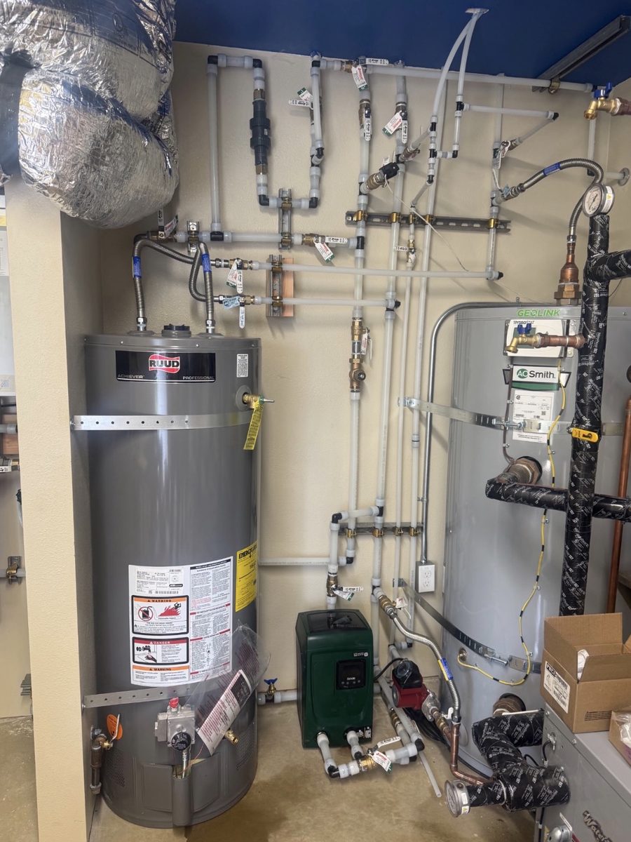 Mechanical room with gas and electric water heaters, circulator pump and a PEX manifold wall